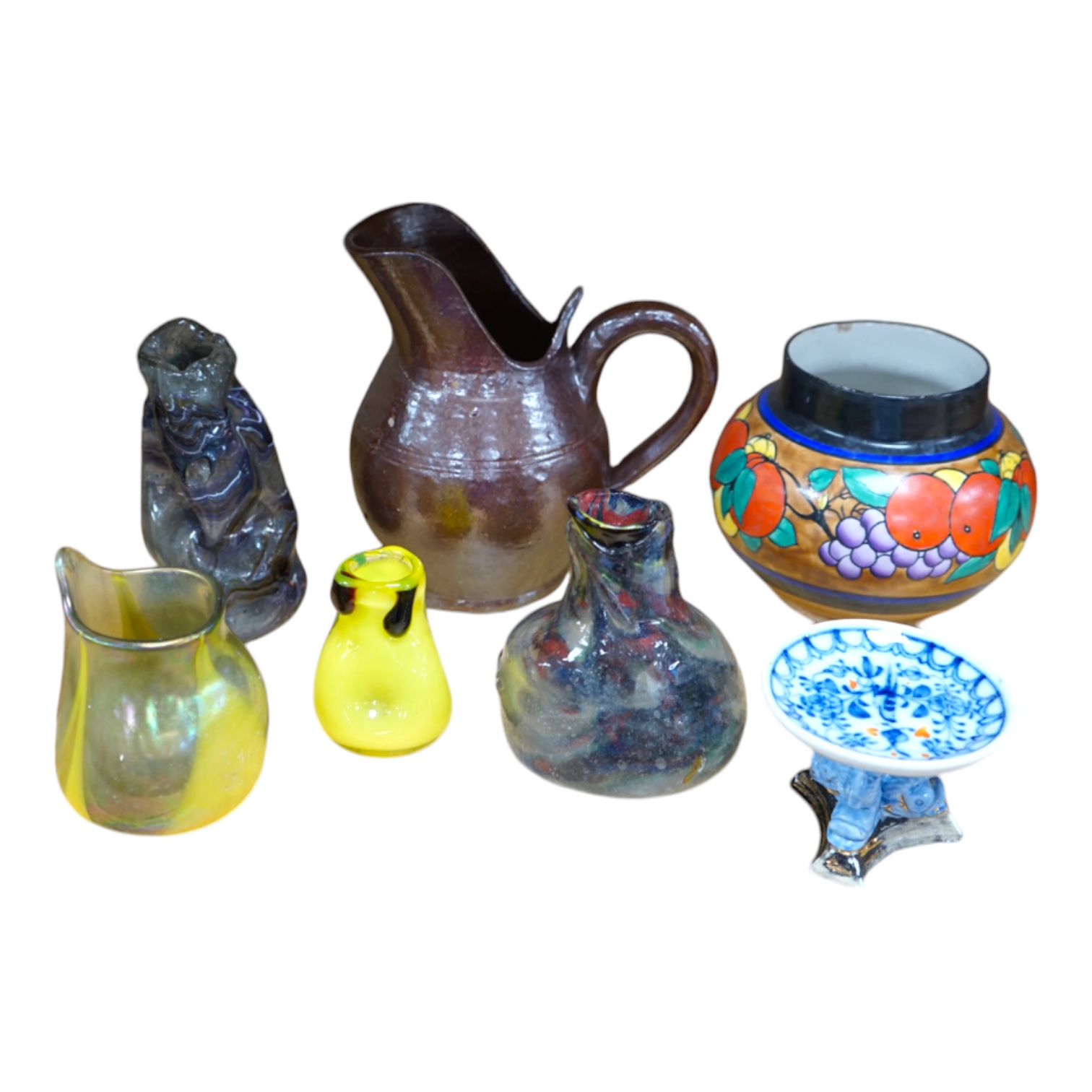 Pottery and glassware to include hand blown vases, a miniature porcelain pedestal dish and a stoneware jug, largest 17cm high. Condition - fair, some chips